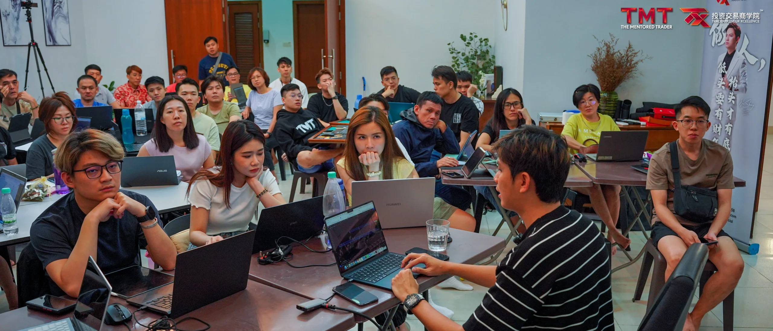 Students with laptops in a TX Academy The Mentored Trader class